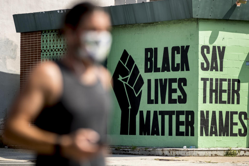 FILE - In this July 13, 2020, file photo, a black lives matter mural is visible in the Shaw neighborhood in Washington. Black Lives Matter activists are holding a virtual Black National Convention Friday, Aug. 28, to adopt a political agenda calling for slavery reparations, universal basic income, environmental justice and legislation that entirely re-imagines criminal justice reforms. (AP Photo/Andrew Harnik, File)