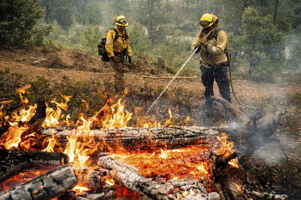 Firefighters mop up hot spots Monday while battling the Oak Fire in the Jerseydale community of Mariposa County, Calif. (Noah Berger / AP)