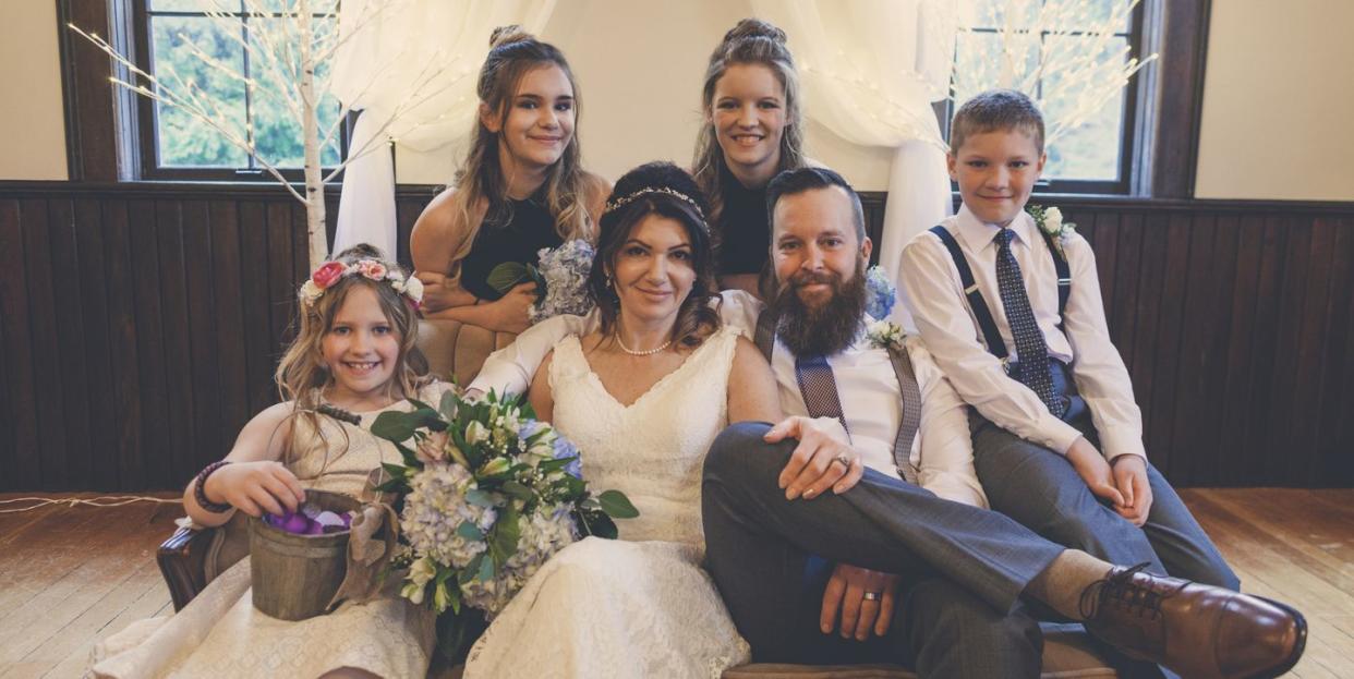 portrait of newlywed couple sitting with their children