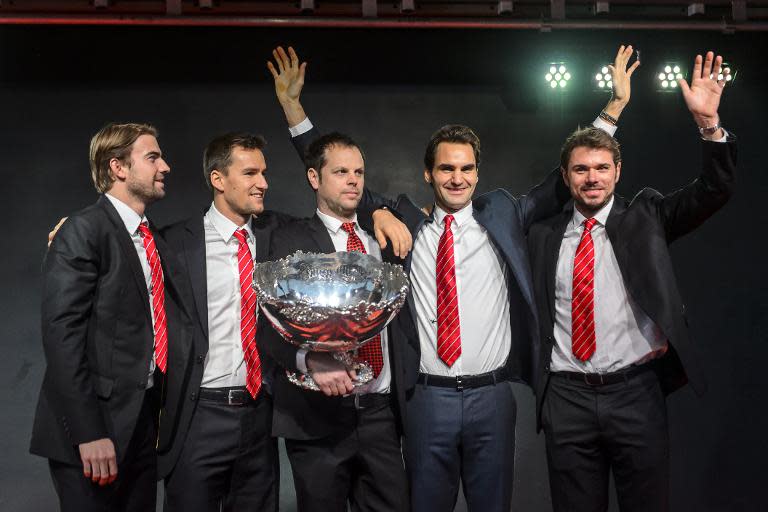 Switzerland's hold on the Davis Cup is under real threat as they take on Belgium without Roger Federer (2nd R) and Stan Wawrinka (R) seen here posing with last year's trophy during the official ceremony, on November 24, 2014 in Lausanne