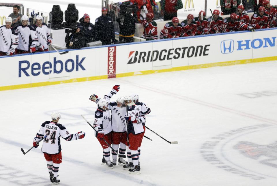 New York Rangers' Carl Hagelin, center, celebrates with teammates after scoring a goal during the second period of an outdoor NHL hockey game against the New Jersey Devils Sunday, Jan. 26, 2014, at Yankee Stadium in New York. (AP Photo/Frank Franklin II)