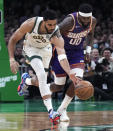Boston Celtics forward Jayson Tatum, left, out runs Phoenix Suns forward Royce O'Neale (00) for a loose ball during the first half of an NBA basketball game, Thursday, March 14, 2024, in Boston. (AP Photo/Charles Krupa)