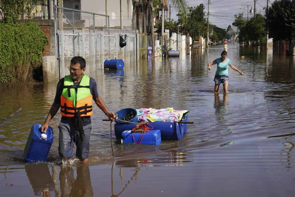 Un ciudadano lleva parte de las pertenencias que ha recuperado flotando tras las inundaciones que anegaron casas debido a las intensas lluvias en Canoas, en el estado de Rio Grande do Sul, Brasil, el jueves 9 de mayo de 2024. (AP Foto/Carlos Macedo)