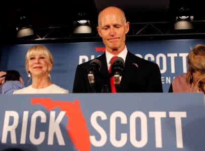 FILE PHOTO: Republican U.S. Senate candidate Rick Scott pauses as he addresses supporters while accompanied by his wife Ann (L) at his midterm election night party in Naples, Florida, U.S. November 6, 2018. REUTERS/Joe Skipper/File Photo