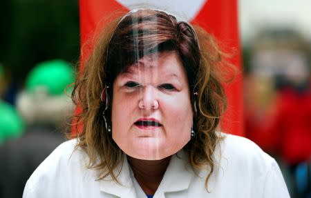 A woman wears a mask depicting Belgian Health Minister Maggie De Block during a protest over the government's reforms and cost-cutting measures, in Brussels, Belgium September 29, 2016. REUTERS/Yves Herman