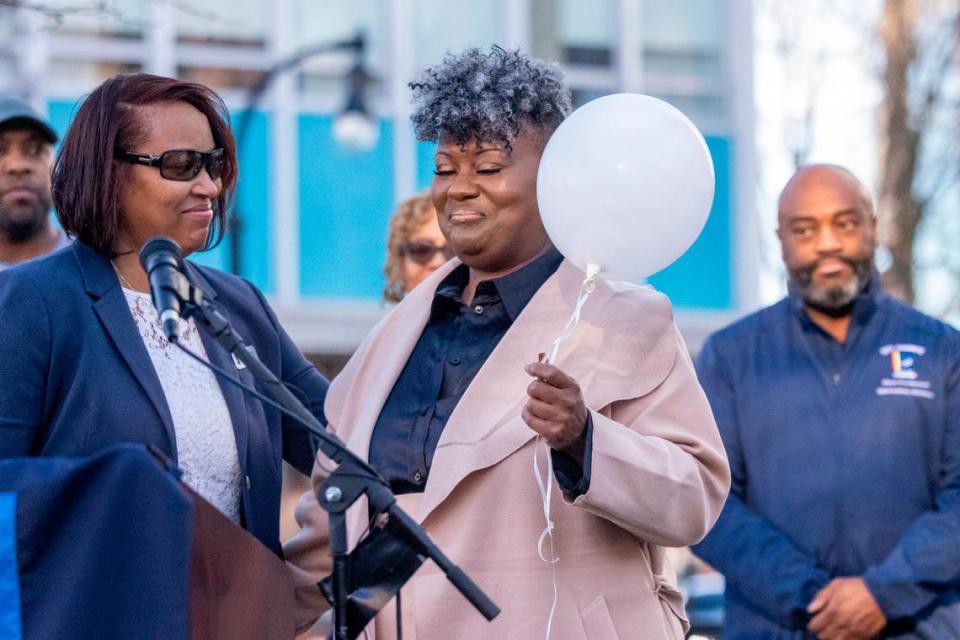 Durham City Council member DeDreana Freeman, left, gives a white balloon to Keshia Gray, a gun violence prevention advocate from Bull City United, during a Day of Remembrance for Gun-Related Homicide Victims ceremony in Durham Friday, Dec. 30, 2022.