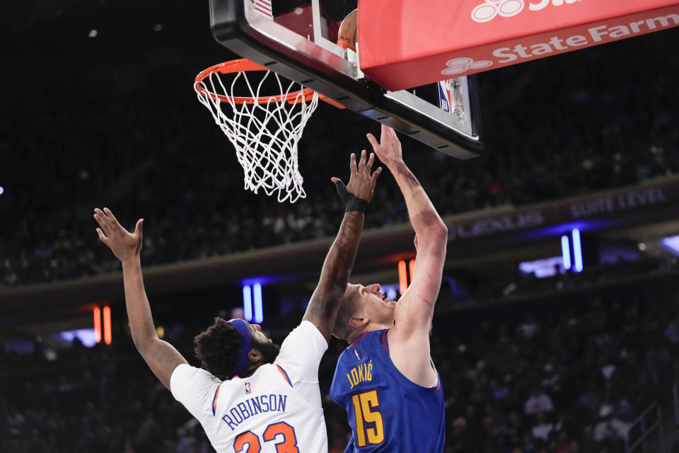 Denver Nuggets center Nikola Jokic (15) goes to the basket against New York Knicks center Mitchell Robinson (23) during the first half of an NBA basketball game, Saturday, March 18, 2023, at Madison Square Garden in New York. (AP Photo/Mary Altaffer)