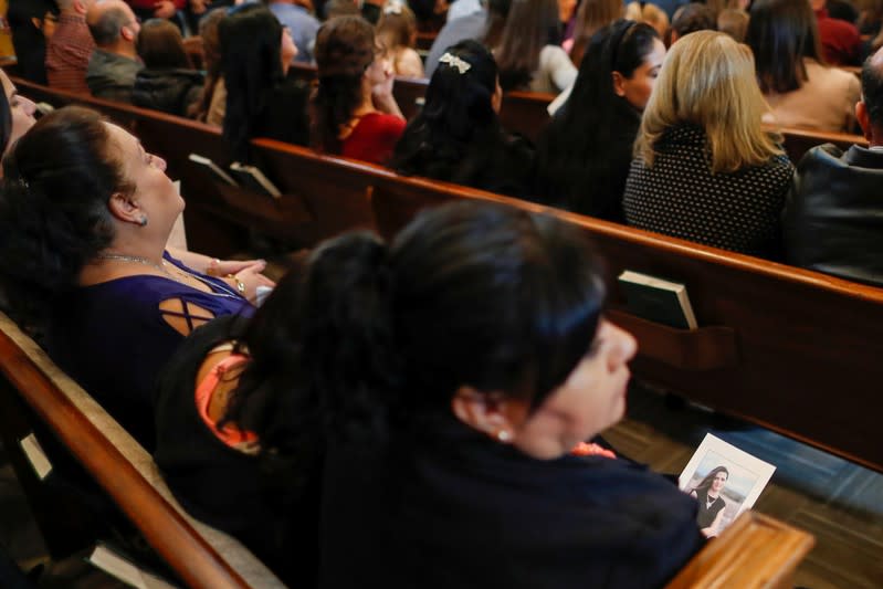 Relatives hold prayer pamphlets with a picture of Christina Marie Langford Johnson, who was killed by unknown assailants, during the funeral service before a burial at the cemetery in LeBaron, Chihuahua