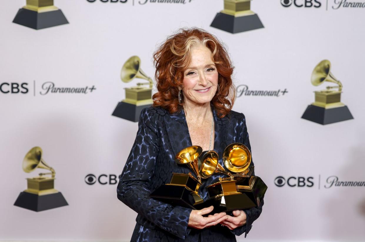 Bonnie Raitt holding her trophy at the Crytpo.com Arena.