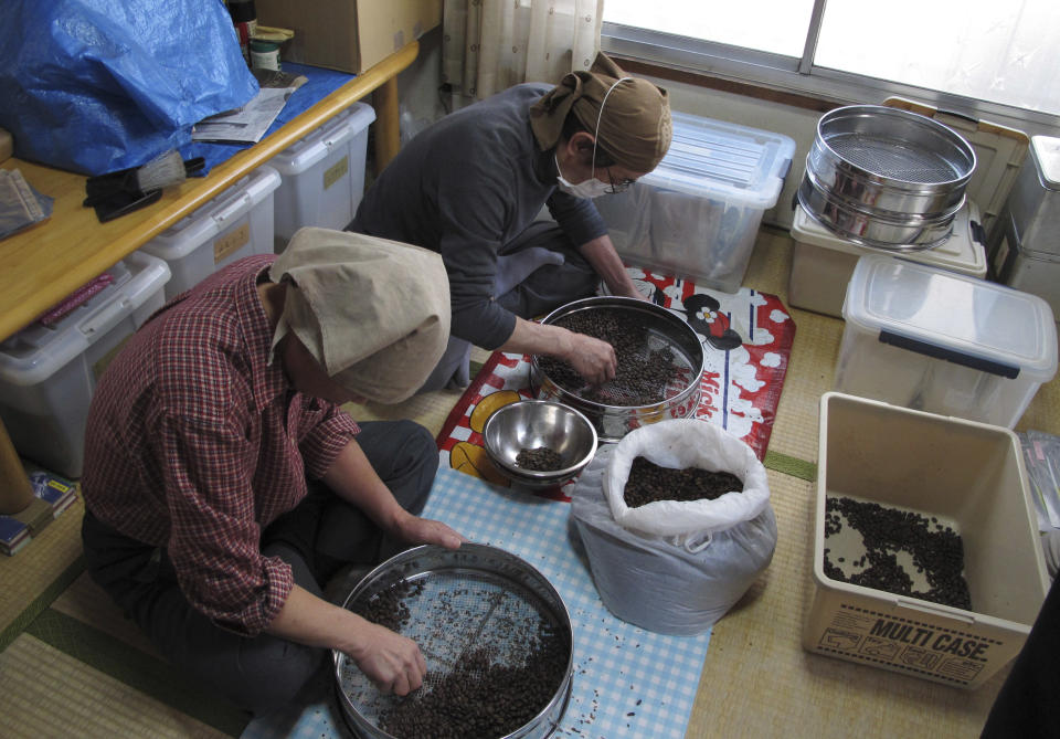 In this Wednesday, Jan. 29, 2014 photo, workers help with a fair trade coffee roasting and sales project at NPO Moyai in downtown Tokyo. The group helps homeless Tokyoites and others fallen on hard times find housing and other support and get back on their feet. Over the past two decades Japan’s system of salaried jobs with full benefits has crumbled as companies struggled to stay afloat in cut-throat global markets, shifting much of their manufacturing overseas. (AP Photo/Elaine Kurtenbach)