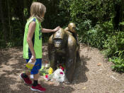 <p>Ein Kind berührt den Kopf einer Gorilla-Statue, vor der Blumen niedergelegt wurden. Im "Cincinnati Zoo & Botanical Garden" im US-Bundesstaat Ohio hat ein Notfallteam einen 17 Jahre alten Gorilla namens Harambe erschossen, nachdem dieser einen vierjährigen Jungen hinter sich her geschleift hatte, der in das Gehege gefallen war. (Bild: AP Photo/John Minchillo) </p>