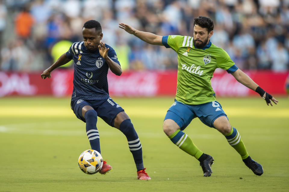 Sporting Kansas City midfielder Gadi Kinda edges around Seattle Sounders midfielder Joao Paulo during the first half of an MLS soccer match, Sunday, Sept. 26, 2021, in Kansas City, Kan. (AP Photo/Nick Tre. Smith)