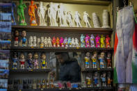 A vendor sells souvenirs of Michelangelo's 16th century statue of David at a kiosk in downtown Florence, Italy, Monday, March 18, 2024. Michelangelo’s David has been a towering figure in Italian culture since its completion in 1504. But curators worry the marble statue’s religious and political significance is being diminished by the thousands of refrigerator magnets and other souvenirs focusing on David’s genitalia. The Galleria dell’Accademia’s director has positioned herself as David’s defender and takes swift aim at those profiteering from his image. (AP Photo/Andrew Medichini)