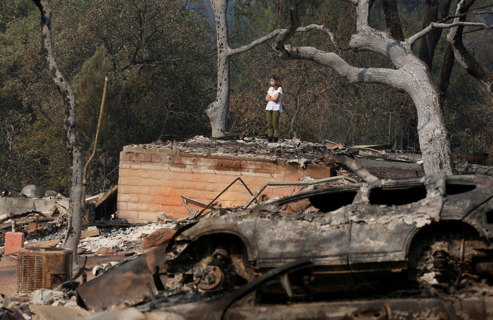 <p>Pamela Garibaldi looks over burned remains of her parents home destroyed by wildfire in Napa, Calif., Oct. 13, 2017. (Photo: Jim Urquhart/Reuters) </p>