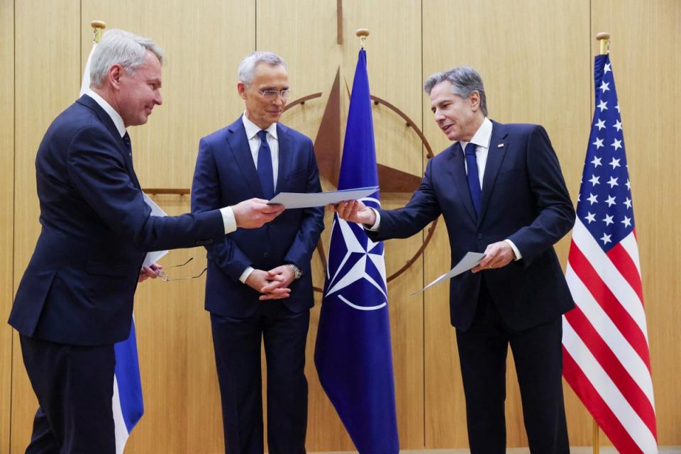 El ministro de Relaciones Exteriores de Finlandia, Pekka Haavisto, a la izquierda, entrega el documento de adhesión de su nación al secretario de Estado de EE. UU., Antony Blinken, mientras el secretario general de la OTAN, Jens Stoltenberg, observa la sede de la OTAN en Bruselas (Reuters)