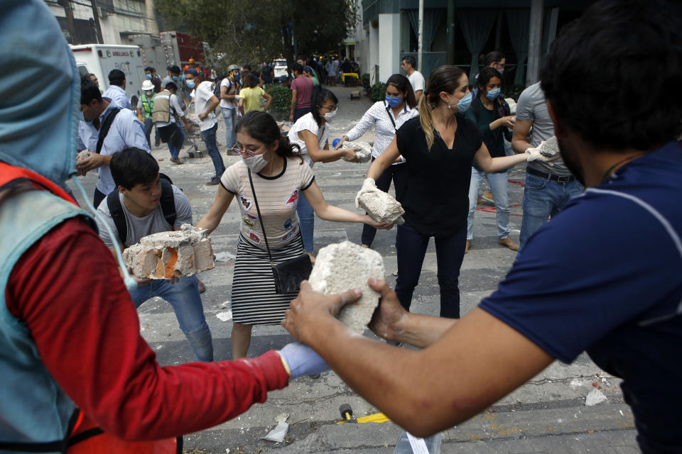 <p>Volunteers pick up the rubble from a building that collapsed during an earthquake in the Condesa neighborhood of Mexico City, Tuesday, Sept. 19, 2017. A powerful earthquake jolted central Mexico on Tuesday, causing buildings to sway sickeningly in the capital on the anniversary of a 1985 quake that did major damage. (AP Photo/Rebecca Blackwell) </p>