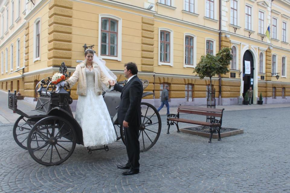 In this photo taken on Oct. 21 2012, a bride and a groom prepare for a photo session on the pedestrian-only Olha Kobylianska street in Chernivtsi, a city of 250,000 in southwestern Ukraine. Known as the Little Paris or, alternatively, the Little Vienna of Ukraine, Chernivtsi is a perfect place for a quiet romantic weekend trip and a crash course in the painful history of Europe in the 20th century. (AP Photo/Maria Danilova)