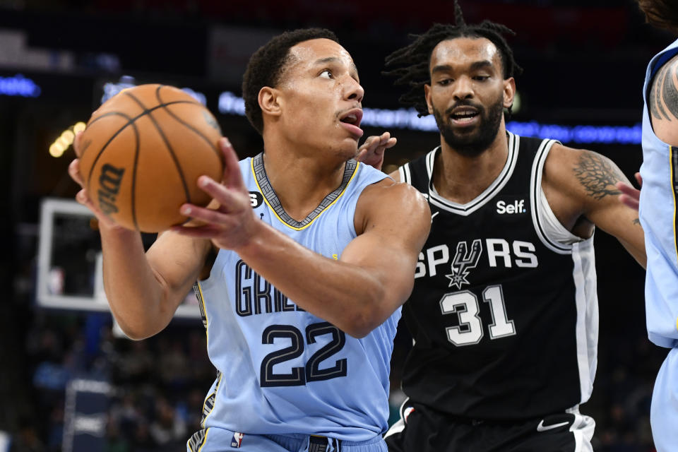 Memphis Grizzlies guard Desmond Bane (22) handles the ball against San Antonio Spurs forward Keita Bates-Diop (31) in the first half of an NBA basketball game, Monday, Jan. 9, 2023, in Memphis, Tenn. (AP Photo/Brandon Dill)