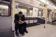 A man wears a mask as he reads on a tube in London, Monday, March 16, 2020. For most people, the new coronavirus causes only mild or moderate symptoms, such as fever and cough. For some, especially older adults and people with existing health problems, it can cause more severe illness, including pneumonia. (AP Photo/Kirsty Wigglesworth)