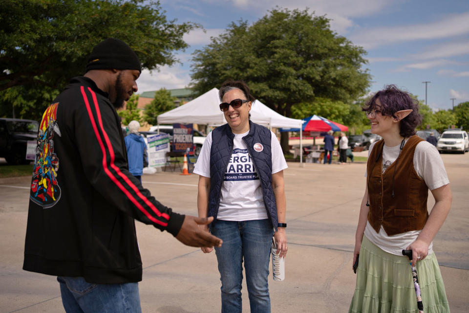 Image: Teddy and their mom, center, speak with GCISD school board candidate Sergio Harris on Saturday. (Danielle Villasana for NBC News)