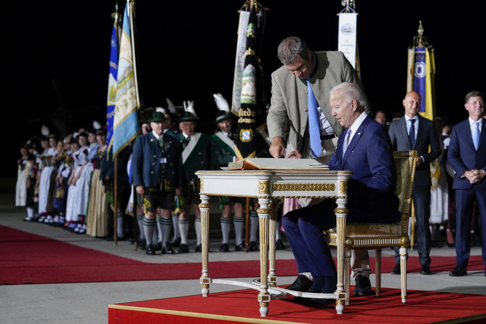President Joe Biden signs the Golden Book of the Bavarian state government after arriving as Markus Soder, Minister-President of Bavaria, stands next to him at Munich International Airport in Munich, Germany, Saturday, June 25, 2022. Biden is in Germany to attend a Group of Seven summit of leaders of the world's major industrialized nations. (AP Photo/Susan Walsh)
