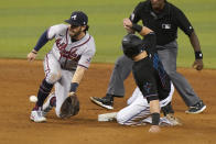 Atlanta Braves shortstop Dansby Swanson, left, attempts to tag Miami Marlins' Adam Duvall, front right, who steals second base during the ninth inning of a baseball game, Saturday, June 12, 2021, in Miami. (AP Photo/Wilfredo Lee)