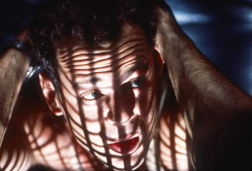 Close-up of man's face seen through window bars