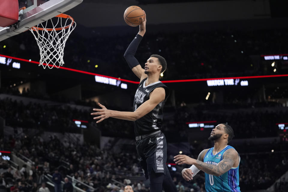 Spurs center Victor Wembanyama scores past Hornets forward Miles Bridges during their game Jan. 12 in San Antonio. (AP Photo/Eric Gay)