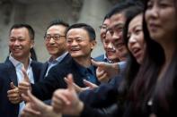 Alibaba Group Holding Ltd founder Jack Ma (C) gestures in front of the New York Stock Exchange before his company's initial public offering (IPO) under the ticker "BABA" in New York September 19, 2014. REUTERS/Lucas Jackson