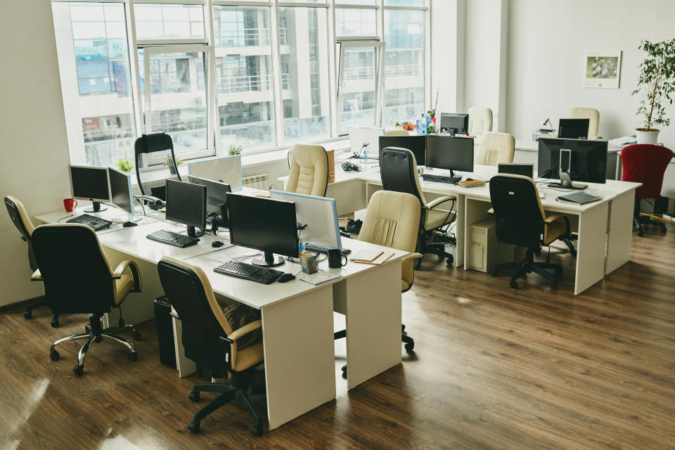 Nobody in a modern office with large window and desks with computers and cups, Covid-19 concept