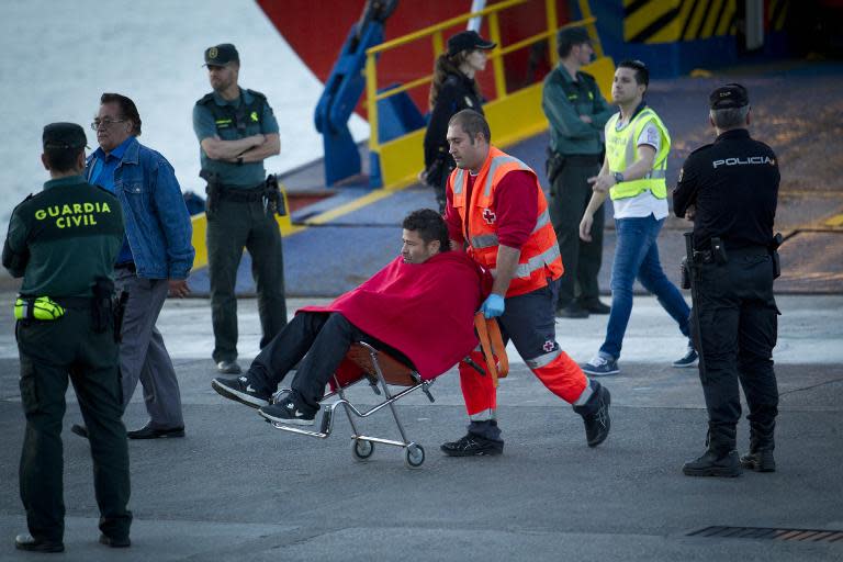 A passenger is helped by a member of the Red Cross upon disembarking from a ship in Palma de Mallorca after the passenger ferry they were travelling on caught fire, on April 28, 2015