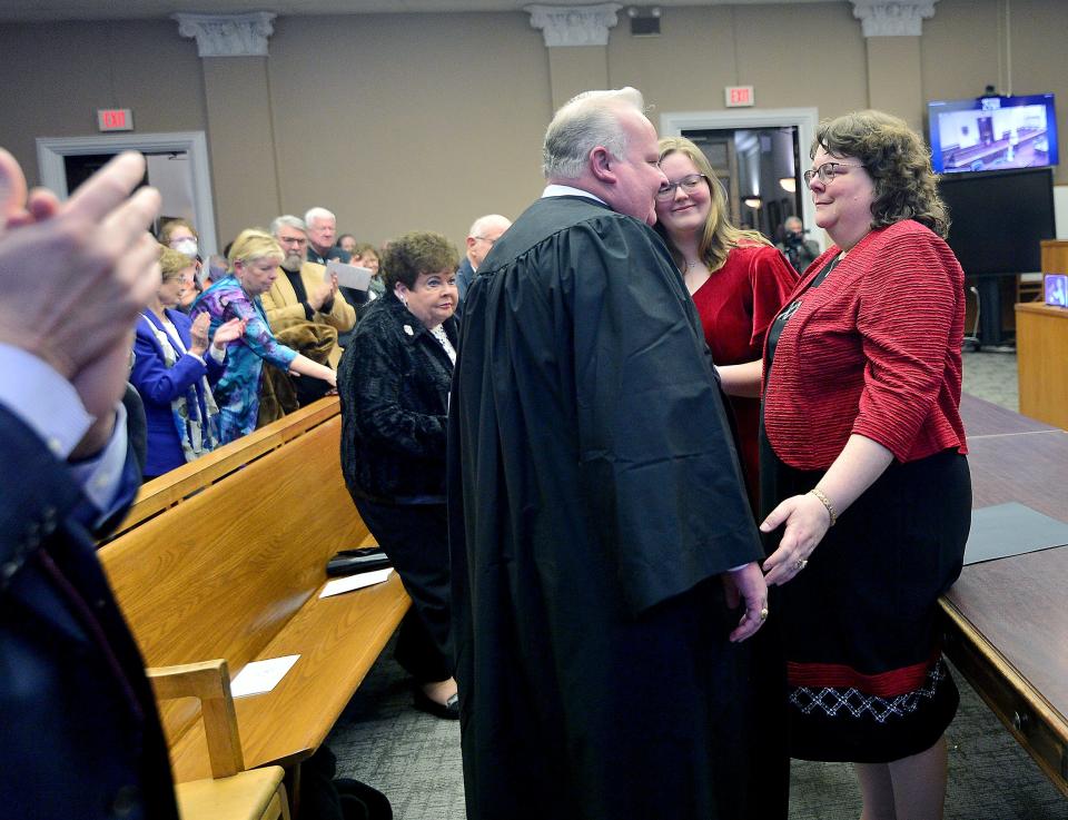 Kirk C. Downey puts on his robe after being sworn in as associate judge of the Washington County Circuit Court on Friday in the Washington County Courthouse in downtown Hagerstown. Helping with the presentation of the robe are Downey's wife Eileen, right, and daughter Erin, center.