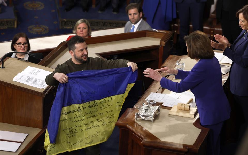 Volodymyr Zelensky gives a battle flag signed by members of the Ukrainian military to Speaker of the House Nancy Pelosi and Vice President Kamala Harris - Getty Images