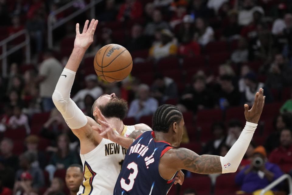 New Orleans Pelicans' Jonas Valanciunas, left, is fouled by Houston Rockets' Kevin Porter Jr. during the second half of an NBA basketball game Friday, March 17, 2023, in Houston. The Rockets won 114-112. (AP Photo/David J. Phillip)