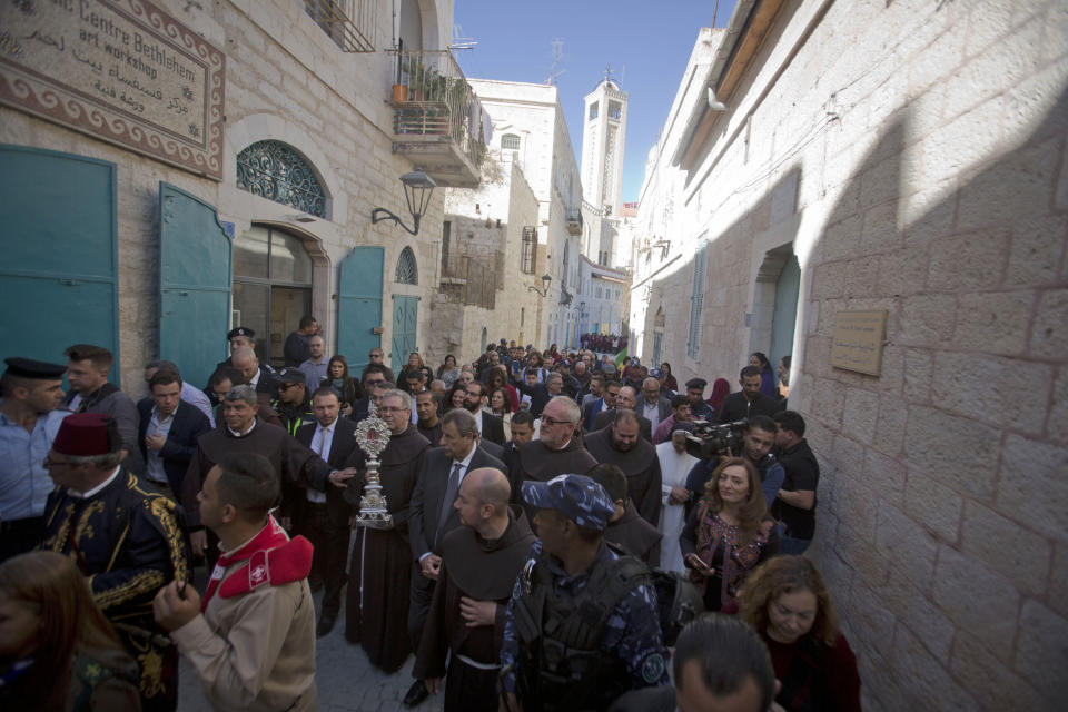 Christian clergymen, carry a wooden relic believed to be from Jesus' manger outside the Church of the Nativity, traditionally believed by Christians to be the birthplace of Jesus Christ in the West Bank city of Bethlehem, Saturday, Nov. 30, 2019. A tiny wooden relic believed to have been part of Jesus' manger has returned to its permanent home in the biblical city of Bethlehem 1,400 years after it was sent to Rome as a gift to the pope. (AP Photo/Majdi Mohammed)