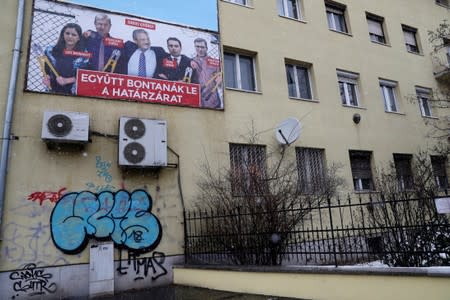 FILE PHOTO: A government billboard shows George Soros and opposition party leaders on a residential building in Budapest