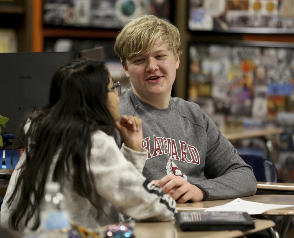 Government class students Alejandra Corral, left, and Braxton Moral work on calculating the estimated cost of living expenses as part of a talk about students who graduate high school making on average more money than non-graduates, at Ulysses High School in Ulysses, Kan., on Wednesday, Dec. 12, 2018. (Sandra J. Milburn/The Hutchinson News via AP)