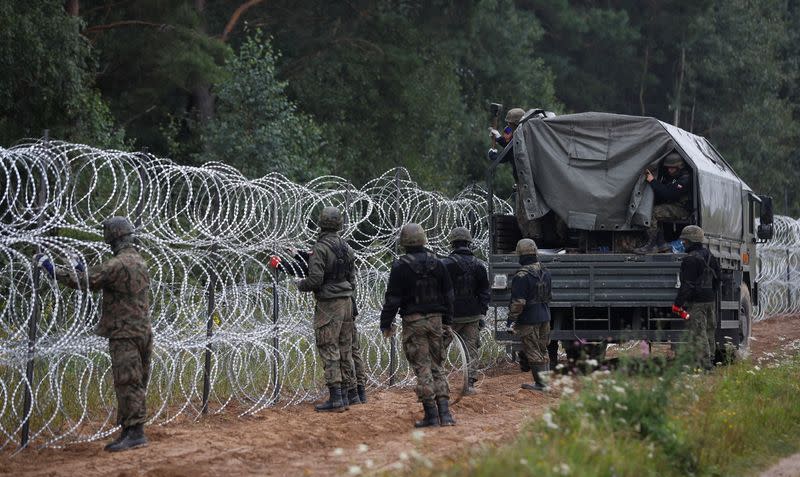 Polish soldiers build a fence on the border between Poland and Belarus near the village of Nomiki