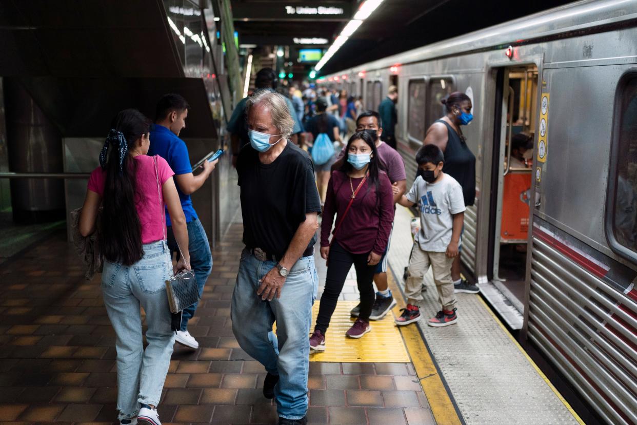 Masked and unmasked commuters are seen at a Metro station in Los Angeles, California on Wednesday, July 13, 2022. 