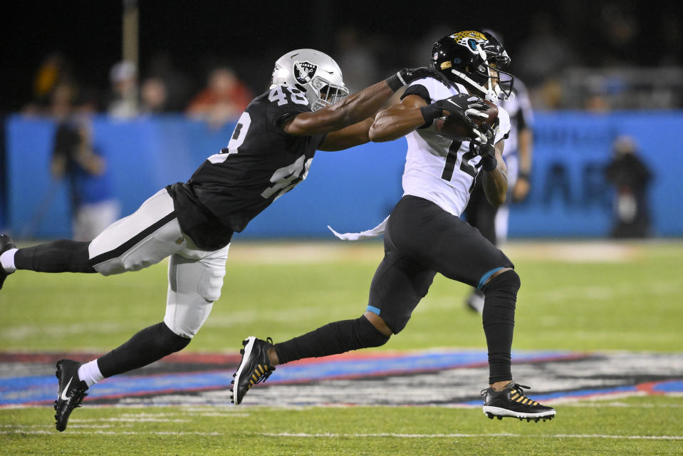 Jacksonville Jaguars wide receiver Marvin Hall (14) runs after a catch with Las Vegas Raiders cornerback Sam Webb (48) defending during the first half of the NFL football exhibition Hall of Fame Game, Thursday, Aug. 4, 2022, in Canton, Ohio. (AP Photo/David Richard)