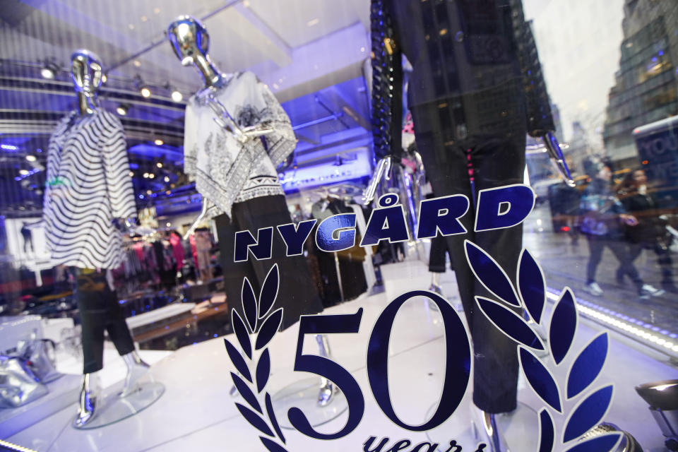 Pedestrians pass the storefront of Peter Nygard's Times Square headquarters, Tuesday, Feb. 25, 2020, in New York. Federal authorities on Tuesday, Feb. 25, 2020, raided the Manhattan headquarters of the Canadian fashion mogul Peter Nygard amid claims that he sexually assaulted and trafficked dozens of teenage girls and young women. (AP Photo/John Minchillo)