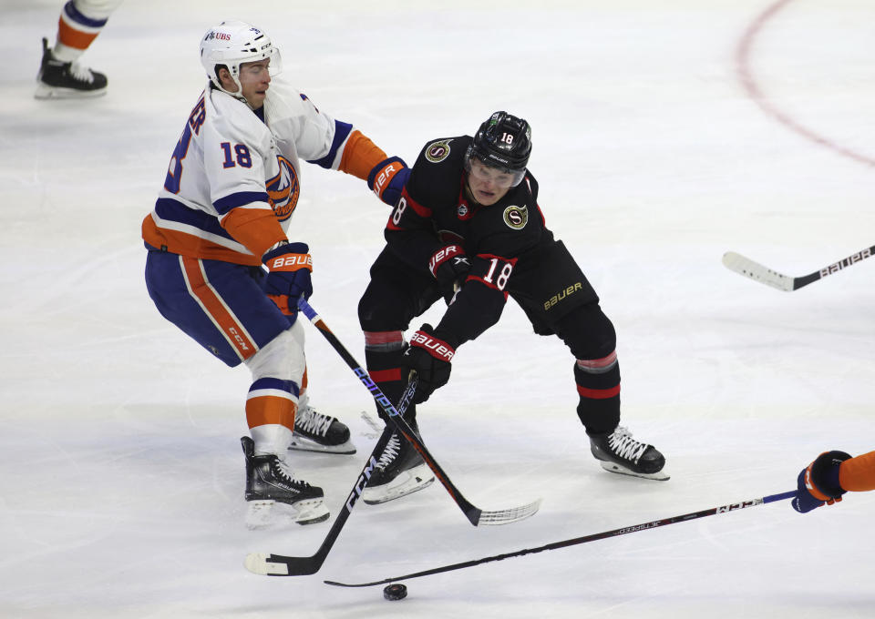 New York Islanders left wing Anthony Beauvillier (18) and Ottawa Senators left wing Tim Stutzle (18) battle for the puck during second-period NHL hockey game action in Ottawa, Ontario, Monday, Nov. 14, 2022. (Patrick Doyle/The Canadian Press via AP)