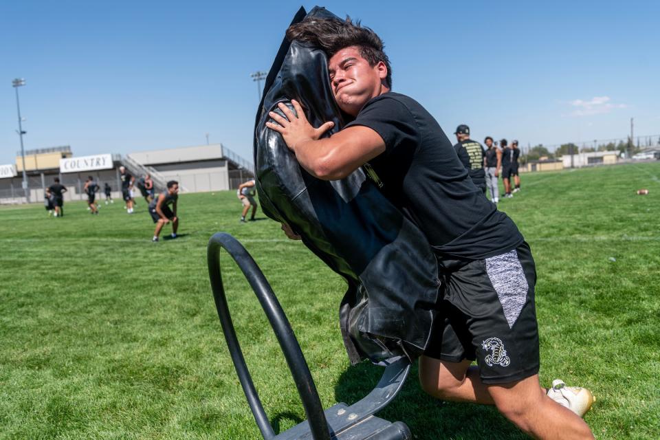 Hesperia's Adan Torres hits a tackling sled during a recent summer football practice at the school. Hesperia begins the season at home against Barstow on Aug. 18.