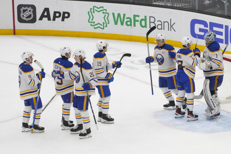 The Buffalo Sabres line up to greet goaltender Ukko-Pekka Luukkonen, far right, as they celebrate a 6-2 win over the Seattle Kraken in an NHL hockey game Monday, March 18, 2024, in Seattle. (AP Photo/Lindsey Wasson)