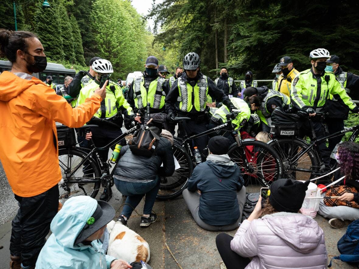 Police attempt to move climate change activists away from the Lions Gate Bridge in Vancouver, B.C., on Monday, May 3, 2021. (Maggie MacPherson/CBC - image credit)