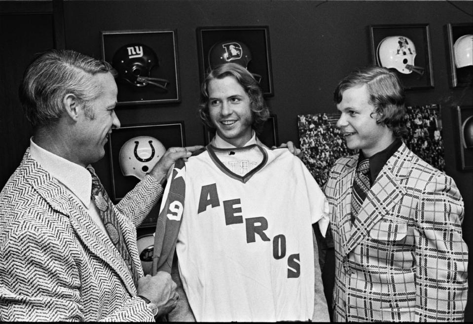 FILE - In this June 5, 1973, file photo, Gordie Howe, left, the former NHL great, checks out the new look for his sons, Marty, center, and Mark, right, after they signed to play with the World Hockey Association team in Houston, Texas. Gordie eventually joined the team, and a made-for-TV movie, "Mr. Hockey: The Gordie Howe Story," focuses on the season the Hall of Famer teamed up with his sons in Houston. The U.S. premiere of the film is Saturday, May 4, 2013. ((AP Photo/Ed Kolenovsky, File)