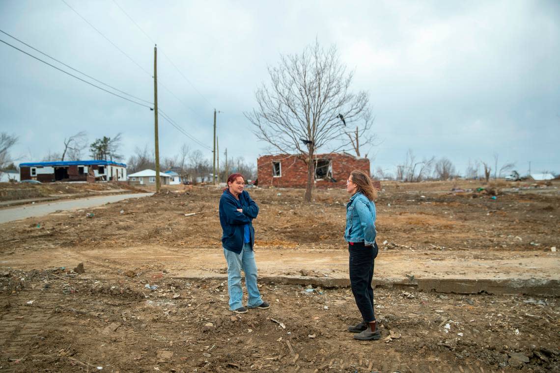 Lexington Herald-Leader reporter Alex Acquisto, right, speaks with Toskia Adamson at the site of her mother’s home in Dawson Springs, Ky., Friday, Feb. 11, 2022. During the Dec. 10, 2021, historic quad-state tornadoes that scoured a path of destruction nearly 200 miles, most of which was in Kentucky, Adamson’s mother and son were sucked out of the home and flung into the air.