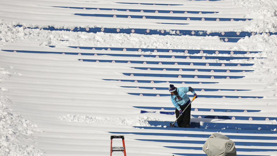 A stadium worker clears snow from seats before an NFL wild-card playoff football game between the Buffalo Bills and the Pittsburgh Steelers, Monday, Jan. 15, 2024, in Buffalo, N.Y. (AP Photo/Jeffrey T. Barnes)