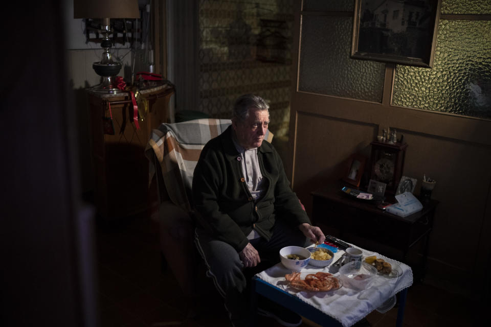 Álvaro Puig Moreno watches television while eating a his Christmas Eve dinner at his home in Barcelona, Spain, Dec. 24, 2020. "The solitude gets to me these days, I often feel depressed," Puig said. "These holidays, instead of making me happy, make me sad. I hate them. Most of family has died, I am one of the last ones left. I will spend Christmas at home alone because I don't have anyone to spend them with." The image was part of a series by Associated Press photographer Emilio Morenatti that won the 2021 Pulitzer Prize for feature photography. (AP Photo/Emilio Morenatti)