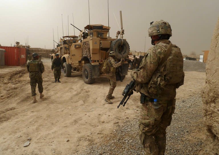 US soldiers stand guard outside a military base near Alkozai village following the shooting of Afghan civilians allegedly by a US soldier in Panjwayi district, Kandahar province on March 11, 2012. The soldier allegedly left the base at night to commit the killings, which included nine children. He allegedly set several of their bodies on fire